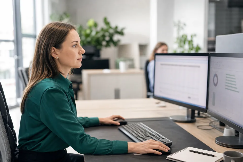 Specjalistka do spraw należności pracuje przy dwóch monitorach